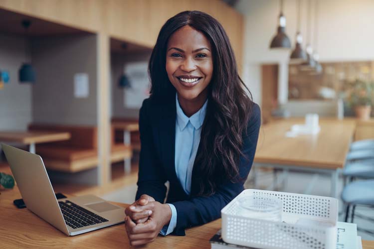 Smiling Female Tax Professional In Dark Blazer In Modern Office Setting