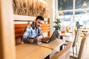 Young man using laptop in a coffee shop